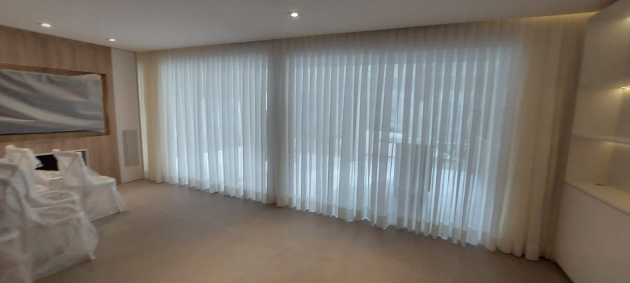 Cortina de voil branca sob medida instalada em uma sala ampla
